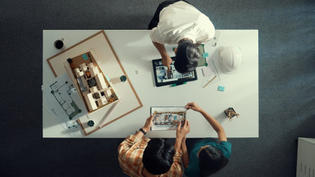 Top down view of civil architect looking at project plan while present to investor at meeting table. Aerial view of skilled designer explain about construction to business people listen. Alimentation.の写真素材