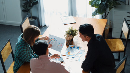 Top view of diverse business team explain marketing idea to investor while manager hold laptop and going for taking a break. Group of creative people explain financial graph at meeting. Convocation.の写真素材
