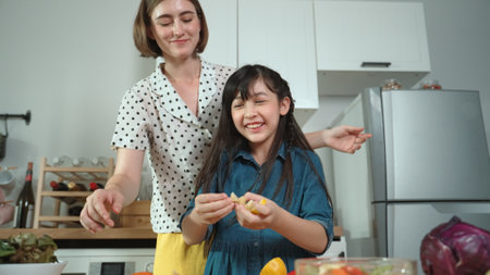 Smart caucasian mother and asian girl cooking together and chopping vegetable or preparing salad for dinner. Happy mom and daughter making healthy food with fresh food. Healthy food concept. Pedagogy.の写真素材