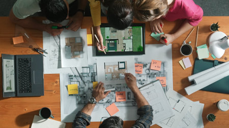 Top down view of engineer planning and writing at blueprint. Architect team working together to...