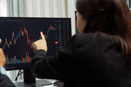 Two business traders discussing on dynamic stock market in currency rate investment trading on two...