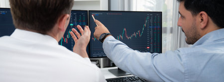 Stock exchange traders discussing on market stock comparing with two screen in chart on panorama...