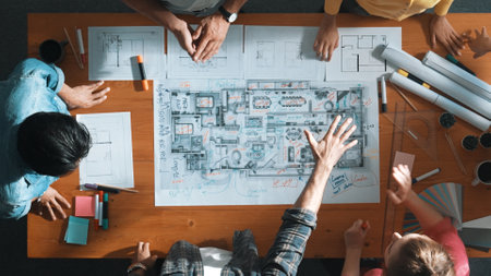 Top view of civil engineer team holding blueprint and standing at table with laptop, project plan and blueprint. Aerial view of skilled project manager planning and writing on sticky notes. Symposium.の写真素材