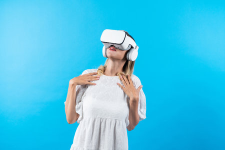 Skilled girl in pajamas excited with metaverse by using VR goggle at background. Caucasian woman...