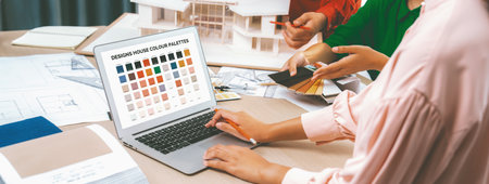 Cropped imaged of professional interior designers choose color material for project with house model...