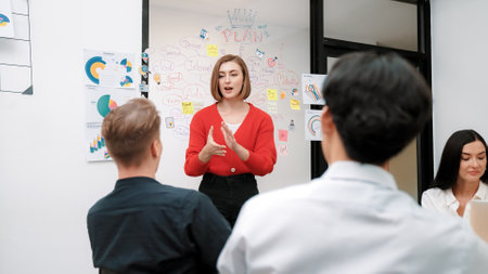 Young beautiful caucasian businesswoman presenting marketing strategy by using mind map, graph while answering questions with confident. Teamwork, brainstorming, discussing concept. Immaculate.の写真素材