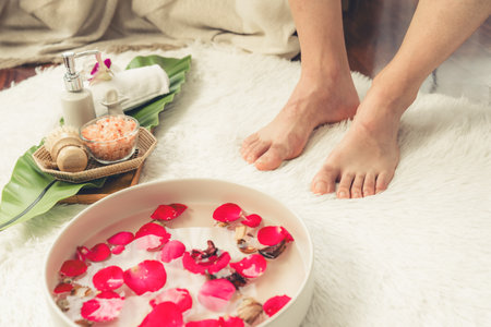 Woman indulges in blissful foot massage at luxurious spa salon while masseur give reflexology therapy in gentle day light ambiance resort or hotel foot spa. Quiescentの写真素材
