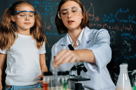 Teacher in support and watch student in laboratory they wear safety glasses, stand and experiment...