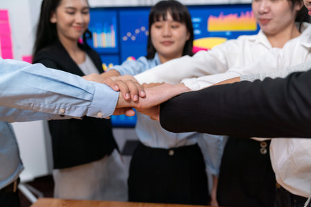 Multicultural business people holding hand together in circle. Unity teamwork in office business workplace. Diverse ethnic office worker engaged in team building. Meticulousの写真素材