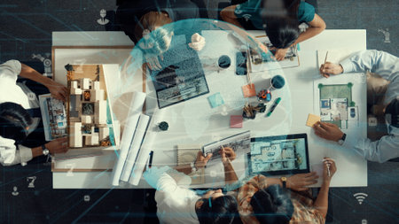Architect team discussing about building construction. Aerial view of professional engineer brainstorming and planning blueprint with global communication holographic at meeting table. Alimentation.の写真素材