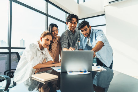 Asian project manager uses laptop displayed data analysis while professional business team brainstorming marketing idea at business meeting. Working together,sharing idea, planing strategy. Tracery.の写真素材