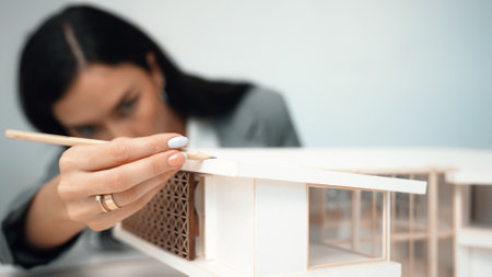 Closeup of professional beautiful young architect engineer focus on measure house model length at modern office while analysis building structure for interior design. Business design. Immaculate.の写真素材