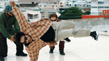 Professional hispanic break dancer practice B boy dance while multicultural friends at roof top with cityscape, urban. Young modern dancing group doing hip hop movement. Outdoor sport 2024. Endeavor.の写真素材