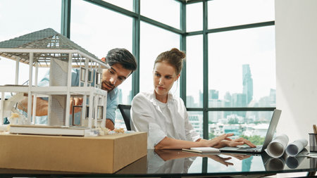 Smart architect engineer inspect house model while colleague using laptop analysis data....