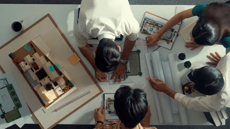 Top down view of smart architect engineer measure blueprint by using architectural equipment while...