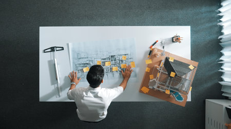 Top down view of skilled engineer team compare between blueprint and house plan. Aerial view of group of architect or designer discussing and point note to brainstorm about blueprint. Alimentation.の写真素材
