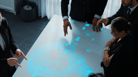 Top view of project manager looking hologram of global networking connection table surrounded by diverse business people brainstorm and planning strategy by using digital communication. Directorate.の写真素材