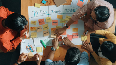 Top view of people writing and making scrum task board while writing marketing and planning strategy at colorful sticky notes. Smart team manage work performance by using kanaban board. Convocation.の写真素材
