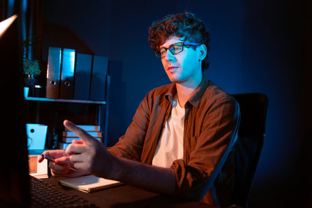 Young businessman concentrating on pc for creative startup project job at neon light modern office....
