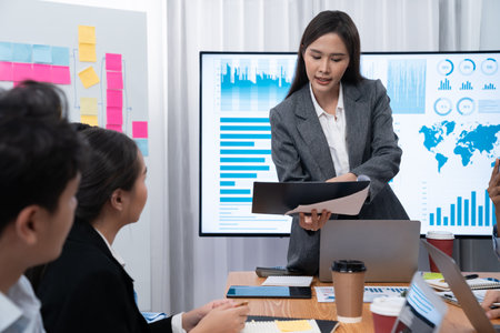 Young asian businesswoman presenting data analysis dashboard on TV screen in modern meeting. Business presentation with group of business people in conference room. Concordの写真素材