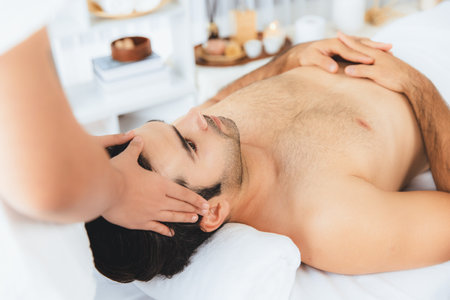 Caucasian man enjoying relaxing anti-stress head massage and pampering facial beauty skin recreation leisure in dayspa modern light ambient at luxury resort or hotel spa salon. Quiescentの写真素材