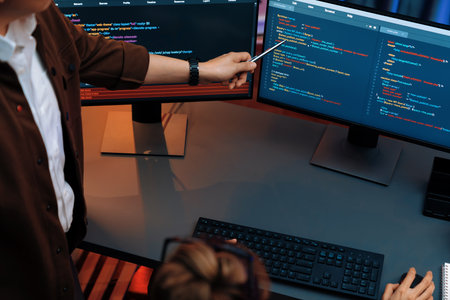 Top view of IT developers discussing with point to intelligent website development coder system running data online two screens information technology at neon light room at modern office. Infobahn.の写真素材