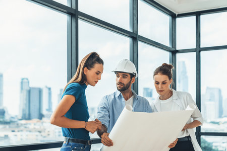 Group of architect engineer looking at project plan while brainstorming idea about building structure. Manager team discuss about building construction while standing near with city view. Tracery.の写真素材