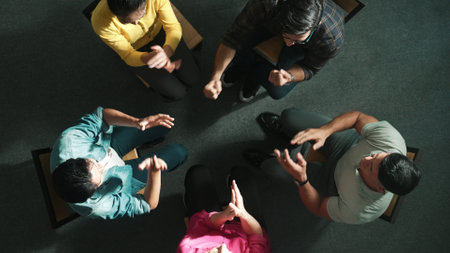 Top down aerial view of business people clap hands together to celebrate successful project while sitting chair circle. Aerial view of skilled marketing team applause successful project. Symposium.の写真素材