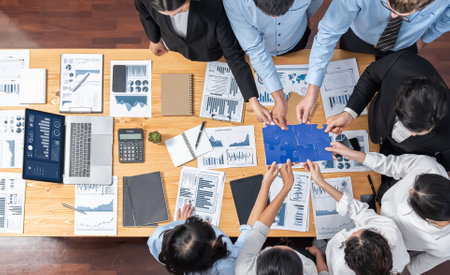 Multiethnic business people holding jigsaw pieces and merge them together as effective solution...