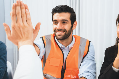 Diverse group of civil engineer and client celebrate and high five after make successful agreement on architectural project, reviewing construction plan and building blueprint at meeting table.Prudentの写真素材