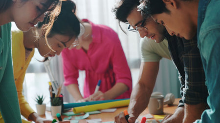 Top view of business team write graphic logo on meeting table with colorful sticky notes and design while explain idea. Project manager sharing idea and explain concept art to smart team. Symposium.の写真素材