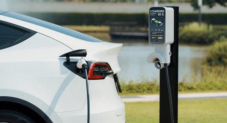 EV electric car recharge battery at parking lot in green city park. Alternative clean energy technology for rechargeable automobile for sustainable and eco friendly urban travel. Expedientの写真素材