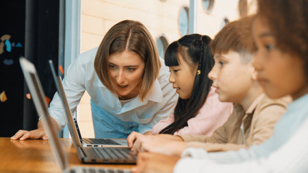 Smart teacher teaching and looking student using laptop at classroom. Professional instructor explained about programing engineering code or prompt while studying and learning program. Erudition.の写真素材