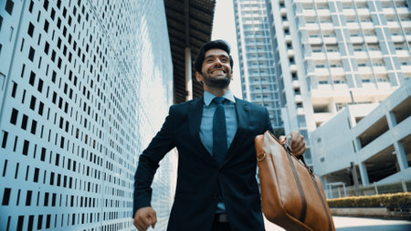 Skilled business man dancing with joyful while walking in city street. Project manger receive a good news, getting promotion, getting a successful job while express feeling of overjoy. Exultant.の写真素材