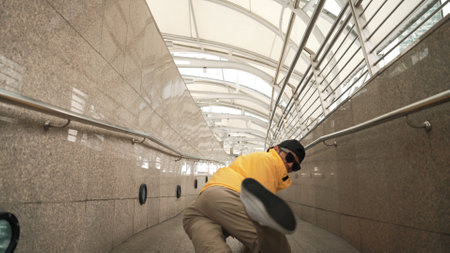 Skilled happy asian hipster walking while dancing in narrow corridor. Close up of break dancer practicing break dance performance. Professional man moving to music. Outdoor sport 2024. Sprightly.の写真素材