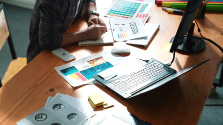 Close up of smart business man hand choosing color palettes while sitting at meeting table with note. Aerial view of interior designer design and select color theme by using color palettes. Symposium.の写真素材
