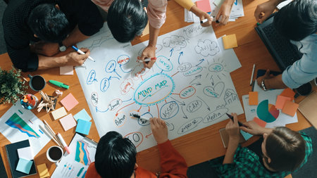 Group of business people writing and making mind map to brainstorming marketing idea at meeting. Top...