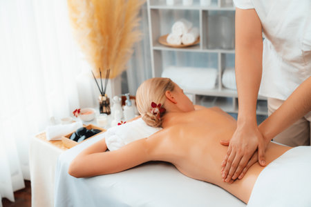 Caucasian woman customer enjoying relaxing anti-stress spa massage and pampering with beauty skin recreation leisure in day light ambient salon spa at luxury resort or hotel. Quiescentの写真素材