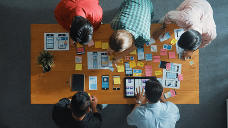 Top down view of business team writing idea on sticky note while planing for Ux Ui design for mobile...