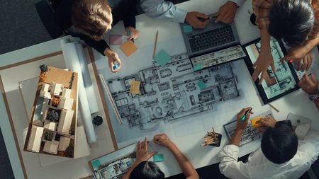 Top aerial view of project manager or civil engineer writing at blueprint and planning building...