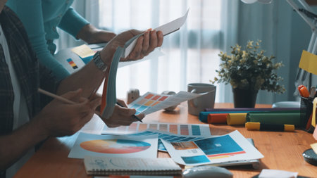 Close up of smart business man hand choosing color palettes while sitting at meeting table with...