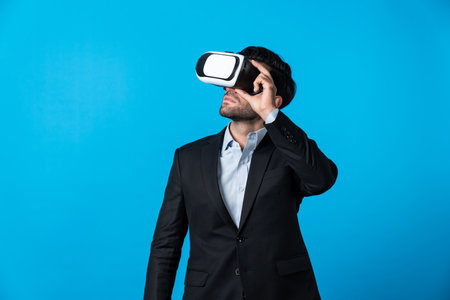 Caucasian business man planning financial plan while using VR goggle. Professional project manager standing and touching VR headset while using visual reality glasses to connect metaverse. Deviation.の写真素材