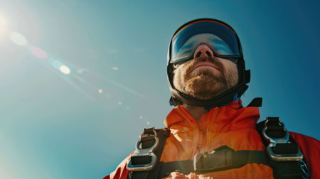 The picture of the professional skydiver wearing goggle doing skydiving in the sky under the bright light of the sun in the morning or noon and also wearing the parachute for safety landing. AIG43.の素材