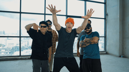 Multicultural hipster group looking at camera while perform break dancing at building with sky scrapper or city view. Street dancer team looking at dancer performance. Outdoor sport 2024. Endeavor.の写真素材