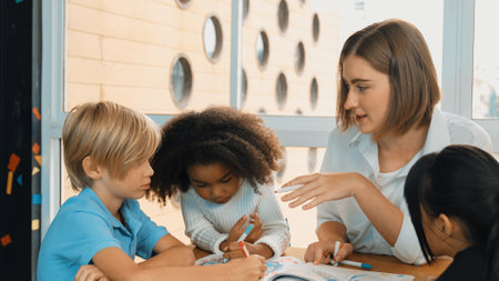 Panorama shot of happy diverse student and smart teacher drawing and coloring by using marker at drawing book. Multicultural learner using drawing book together at art lesson. Relaxation. Erudition.の写真素材