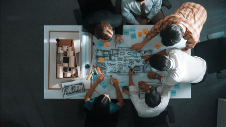 Top aerial view of project manager or civil engineer writing at blueprint and planning building design. Aerial view of architect working together at meeting table with document placed. Alimentation.の写真素材