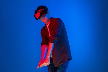 Smart gaming player wearing VR glasses playing golf distance course hologram isolated neon light blue screen connecting digital futuristic technology virtual reality in metaverse world. Contrivance.の写真素材