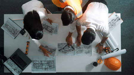 Top down view of project manager and civil engineer hold laptop while explain idea to architect. Aerial view of smart business team talking and brainstorming about building construction. Alimentation.の写真素材