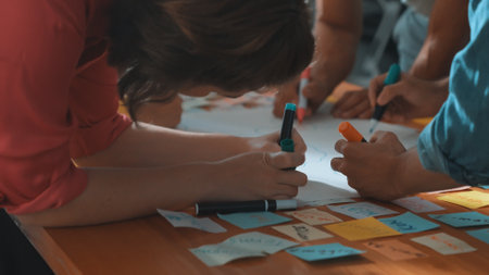 Close up of developer team using mind map to brainstorm idea. Top view of skilled group of business people working together writing marketing strategy by using markers and sticky notes. Symposium.の写真素材