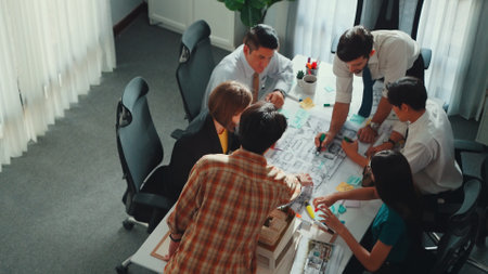 Group of diverse team planning strategy while sitting at table with project plan. Top aerial view of smart business people working together to brainstorm and design house construction. Alimentation.の写真素材